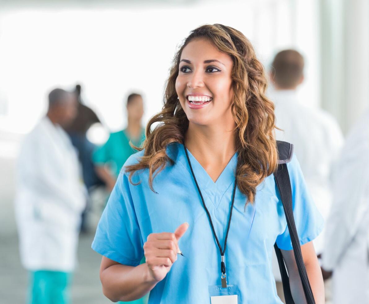 an image of a woman in scrubs smiling while looking to the left