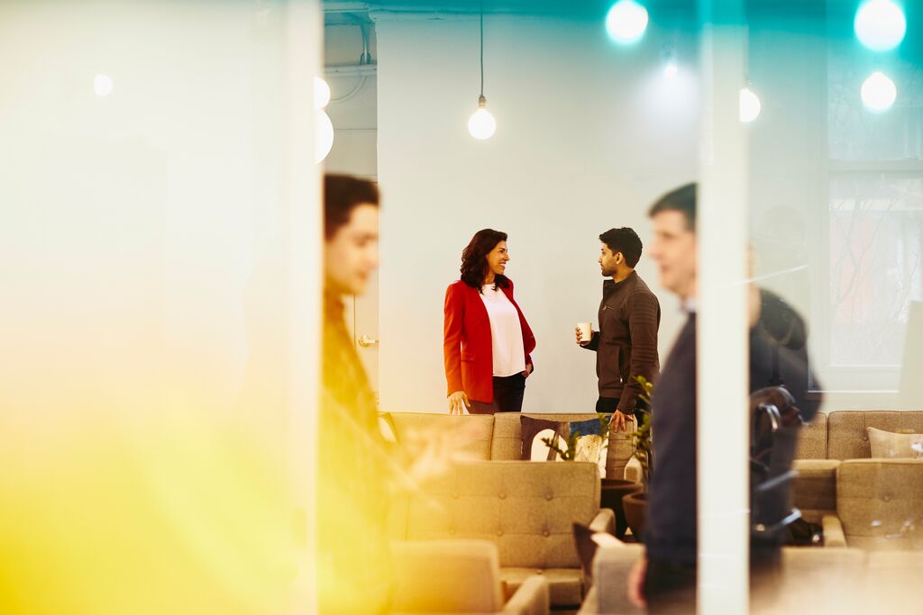 A man and woman are locked in a conversation in the back while two men are in another conversation upfront 