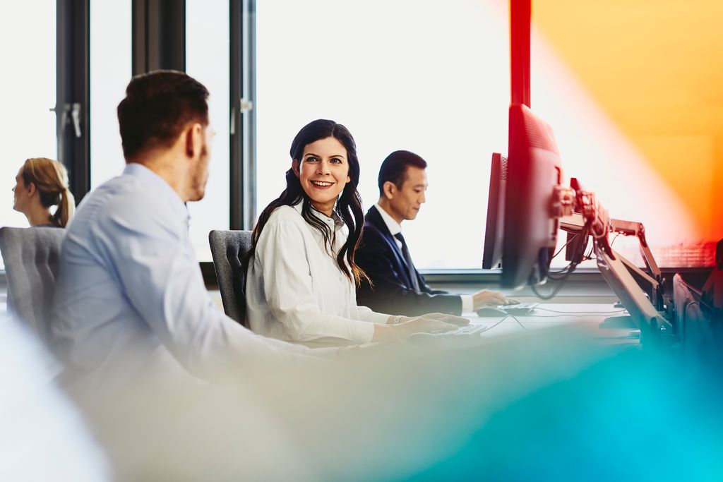 woman happily talking with her colleague in office