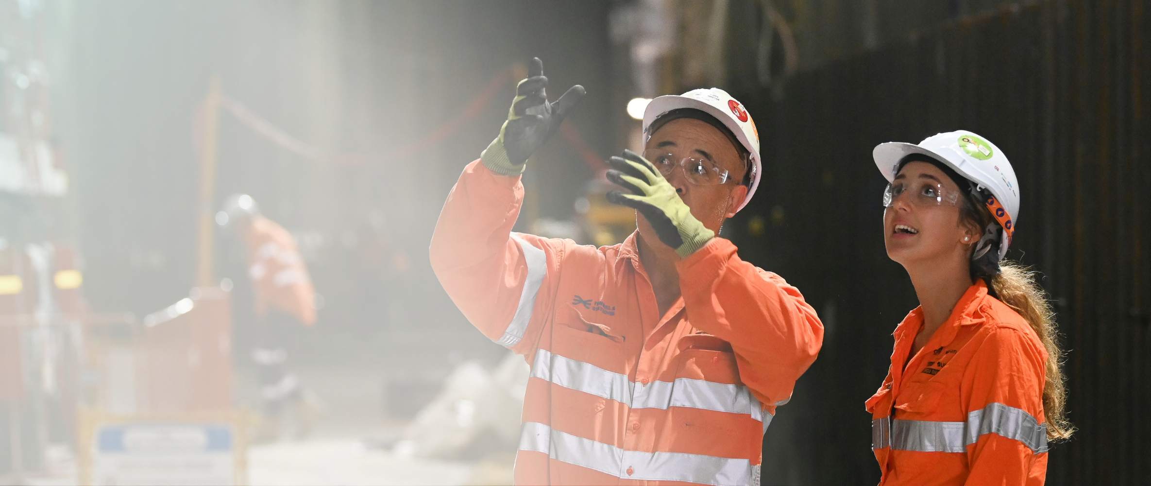 rail engineers in orange uniforms and hardhats working on site