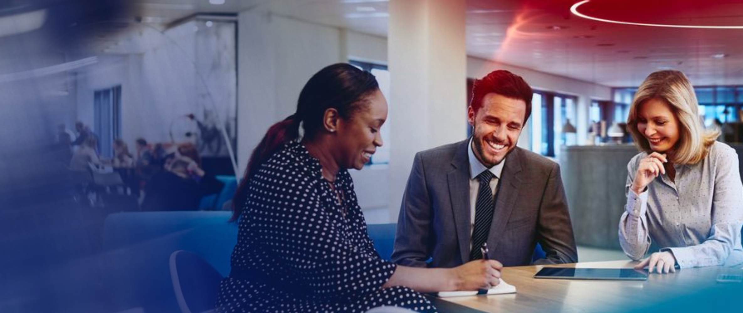 two women and a man in the middle talking in an office space