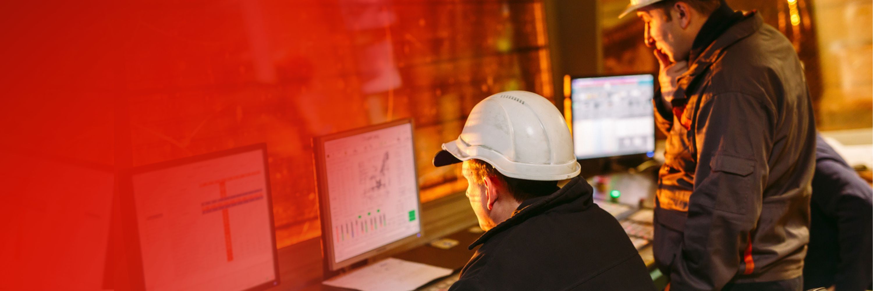 Two men looking at computer screens while wearing hard hats and suits made for construction jobs