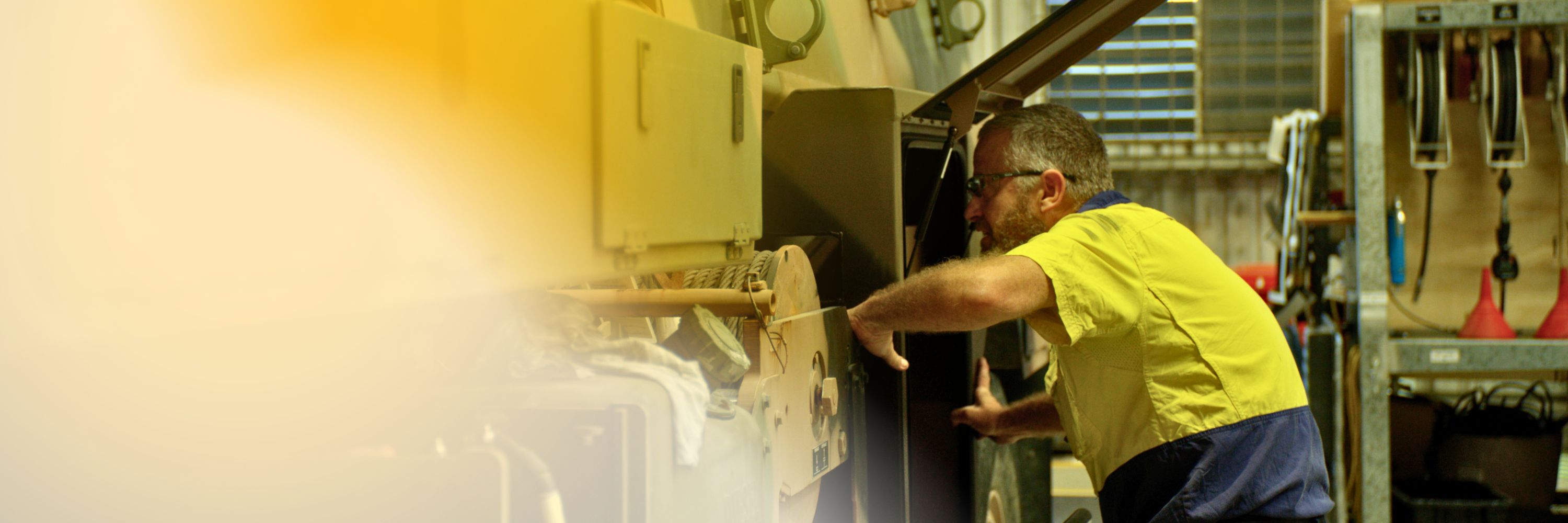 men in a yellow shirt working as a heavy vehicle mechanic