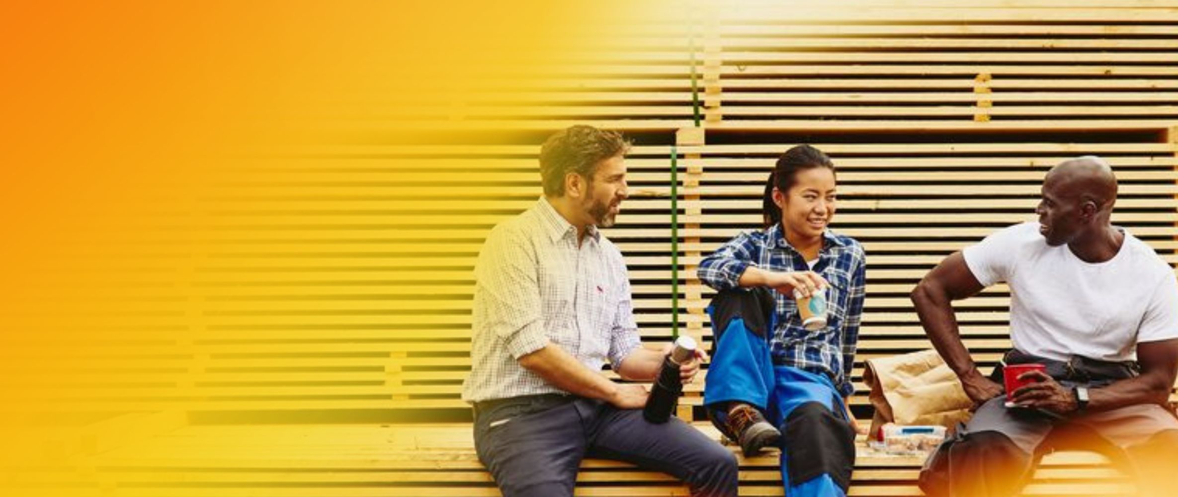 an image of three co workers chatting while sitting down on a stacked platform