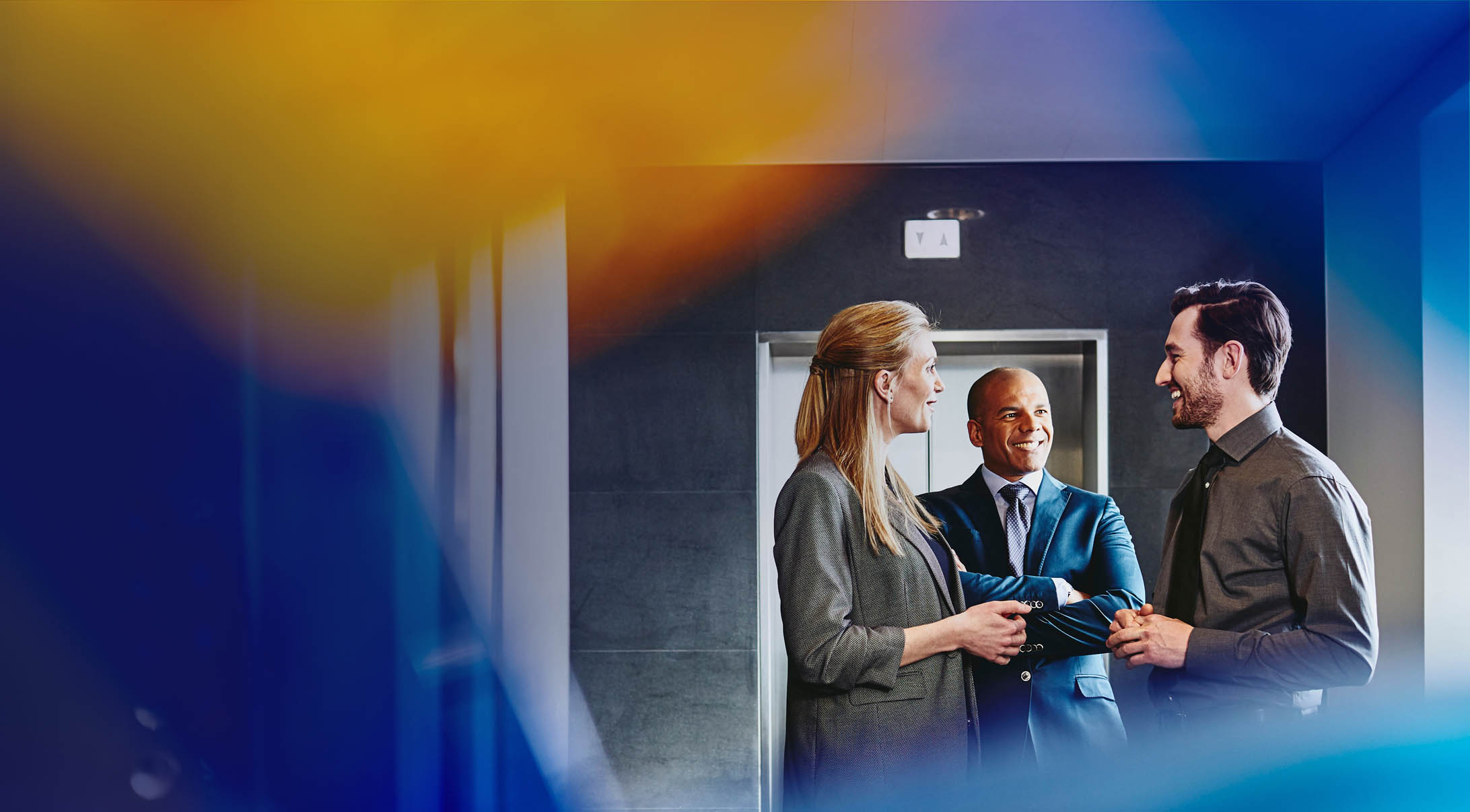 three colleagues having a conversation in an office