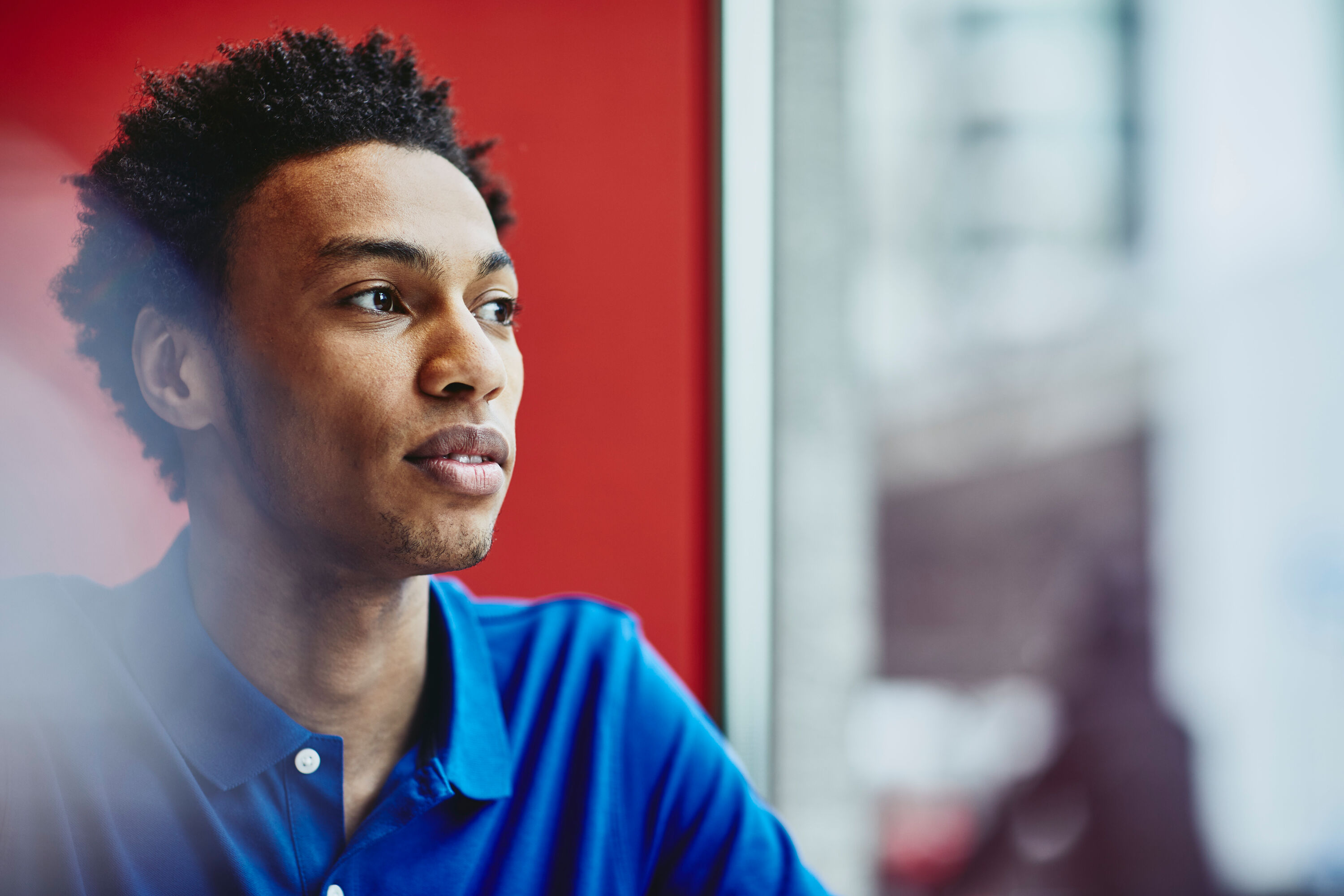 an image of a man wearing a blue collared shirt staring to the right