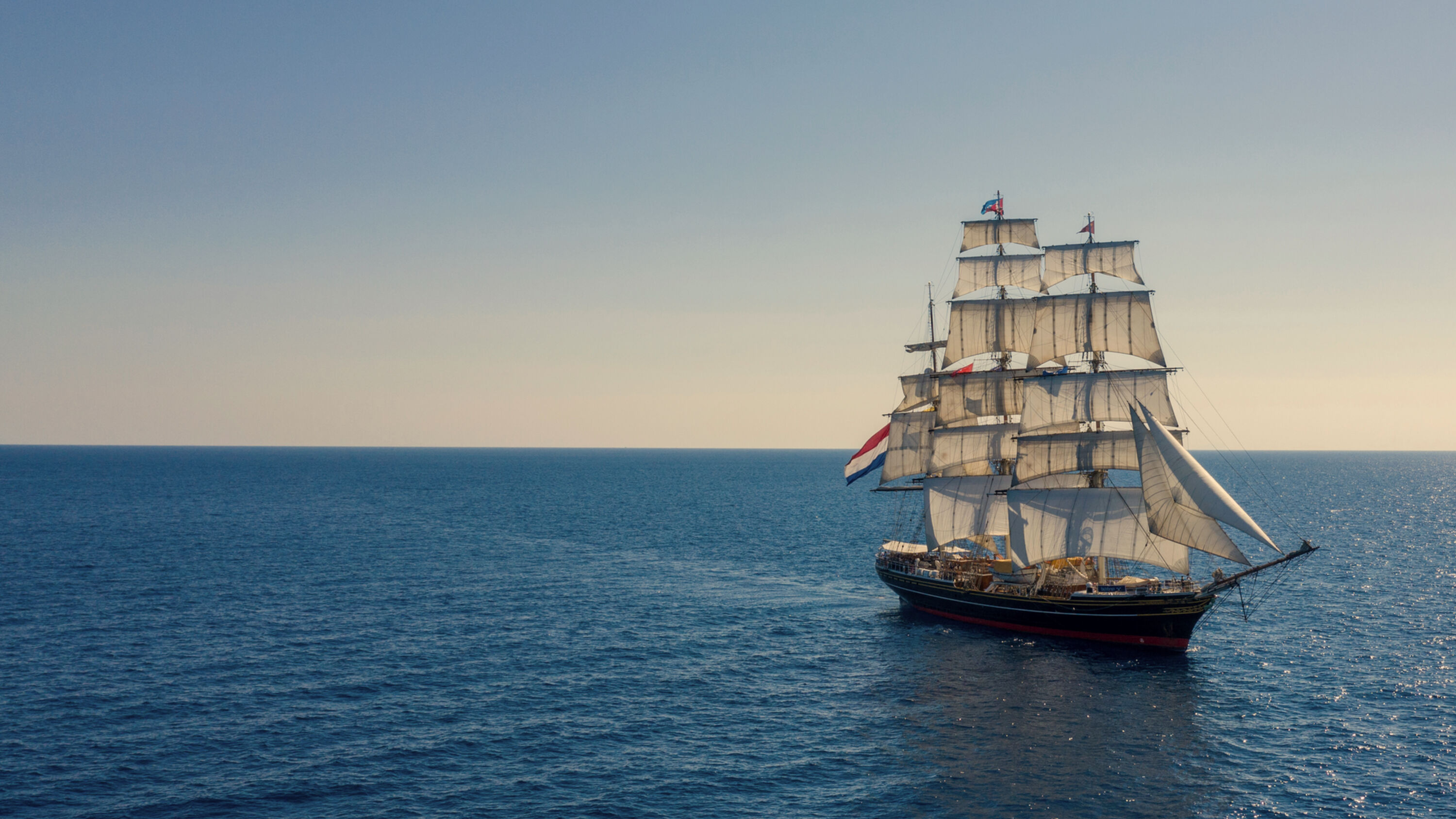 randstad clipper sailing on sea into the sunset