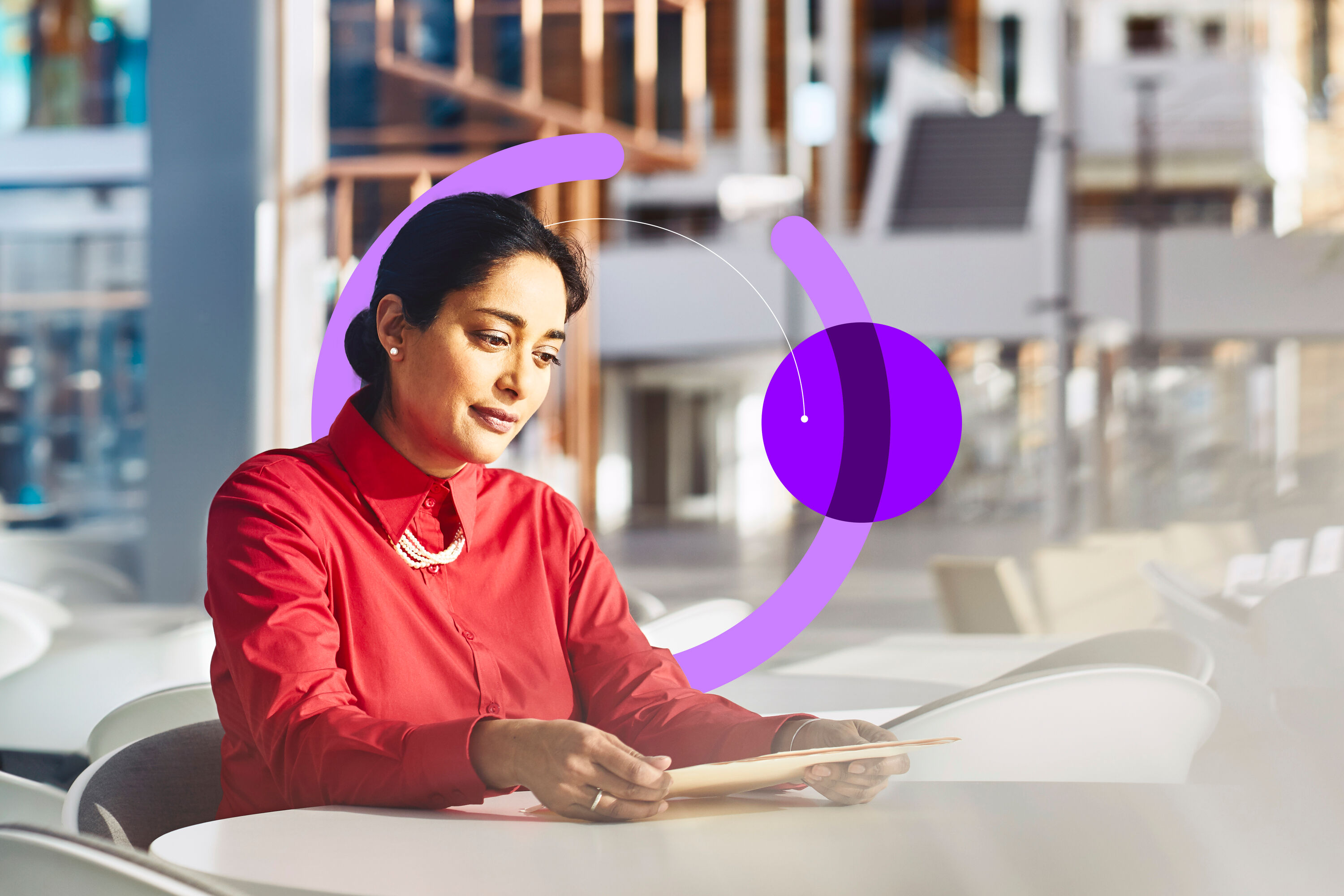 an image of a woman sitting at a table in an office looking at a file