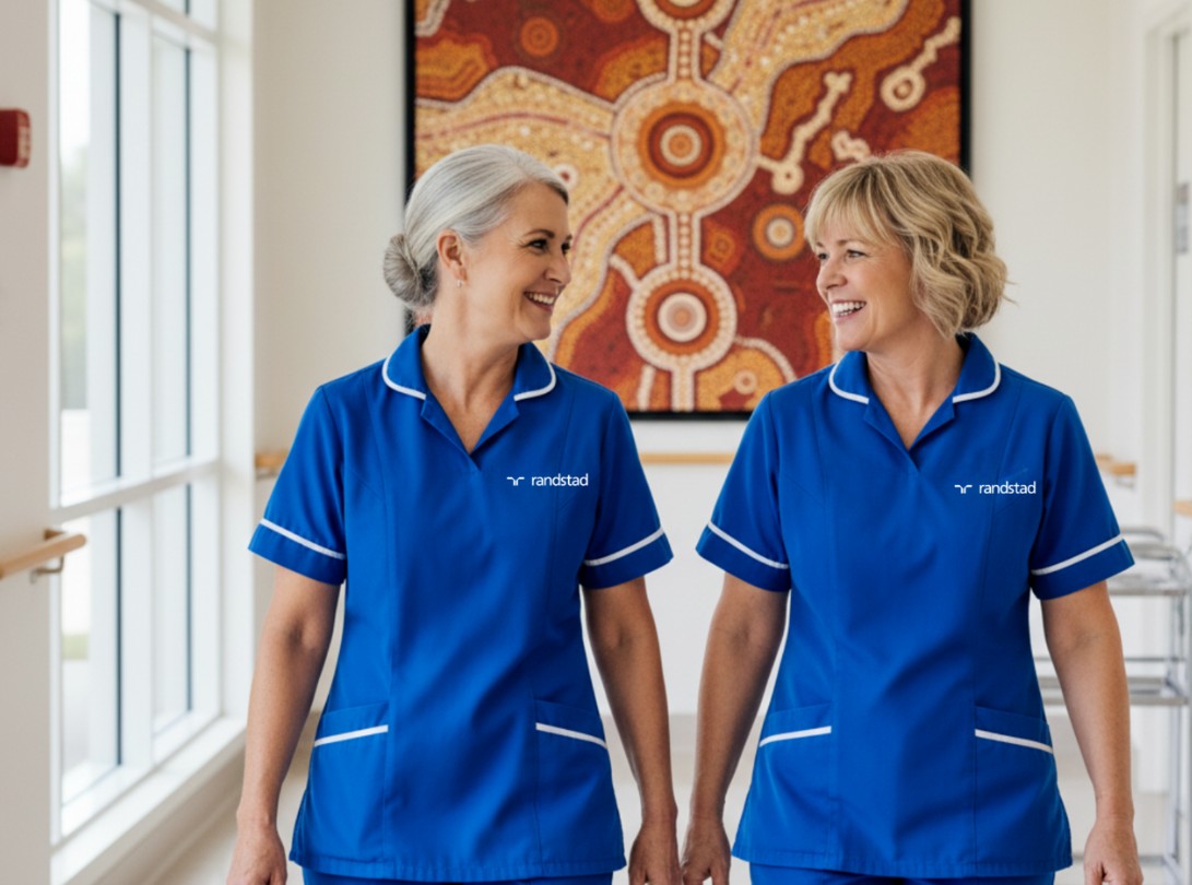 an image of two aged care nurses smiling at each other