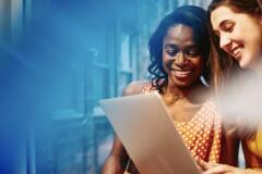 two women smiling working together