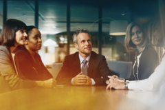 business men and women sitting together at table