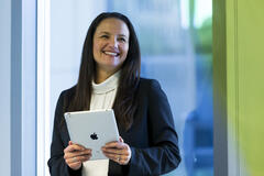 A photo of a woman holding an iPad