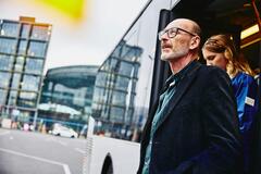 Old man with a woman going getting off a bus
