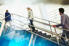 Three people climbing up the stairs