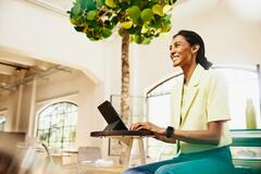 Woman smiling while typing in her tablet