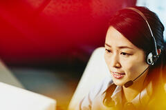 A woman wearing a headset talking to a client