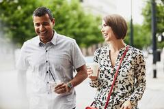 woman and man holding coffee having a friendly chat