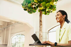 Woman smiling while typing in her tablet