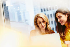 A photo of two women working together 