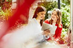 Young women looking at a tablet smiling