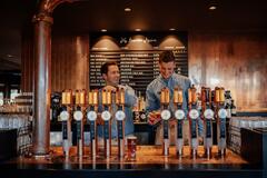 an image of two men fixing up drinks while smiling