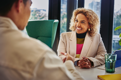 woman in an office talking to a male colleague smiling