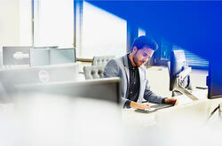 A man looking at his keyboard in a suit 