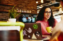 Woman holding a cup smiling at her colleague