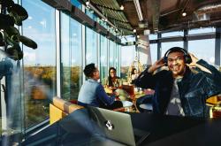 Man listening to music in a cafe with people talking in the back