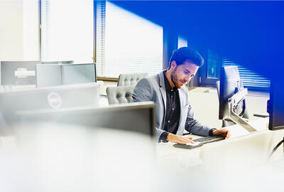 A man looking at his keyboard in a suit 