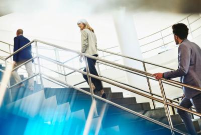 Three people climbing up the stairs