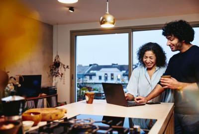 man and woman smiling looking at the computer