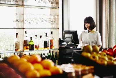 woman in a bar location looking at a computer