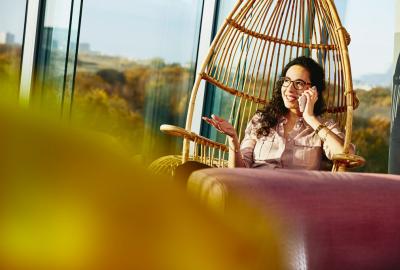 Woman sitting down while talking on the phone.