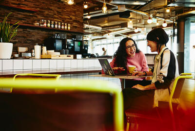 an image of two women having a conversation in a coffee shop 