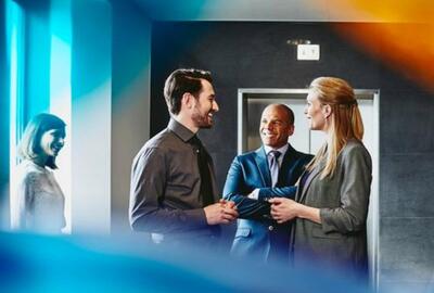 group of colleagues in suits talking in the office