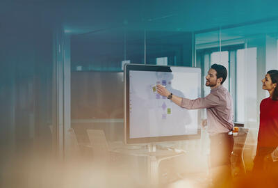group of colleagues in an office brainstorming using a whiteboard