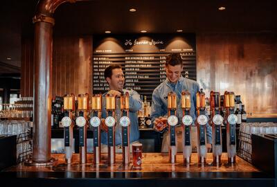 an image of two men fixing up drinks while smiling