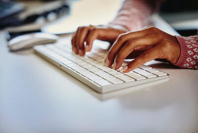 a close up of hands typing on a keyboard