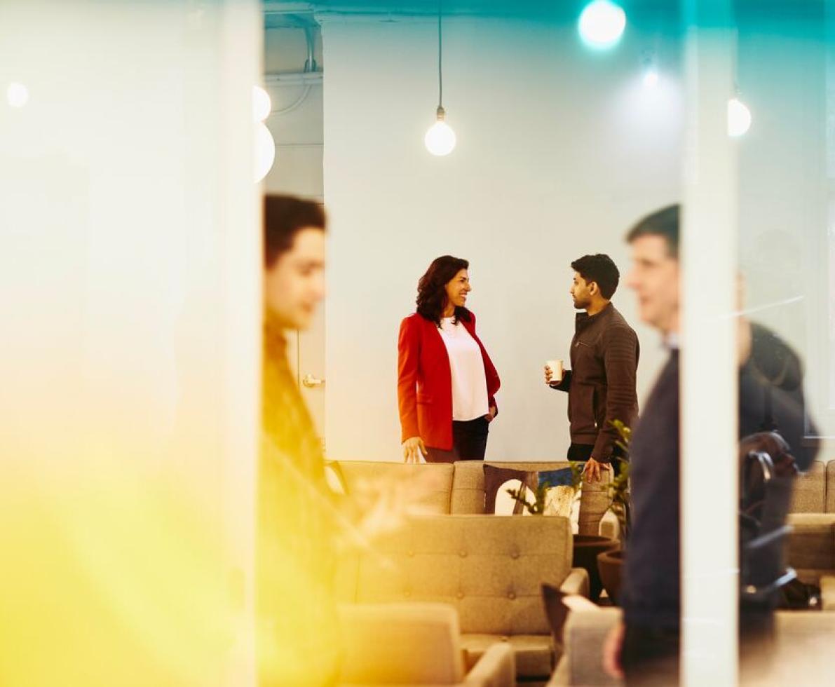 A man and woman are locked in a conversation in the back while two men are in another conversation upfront 