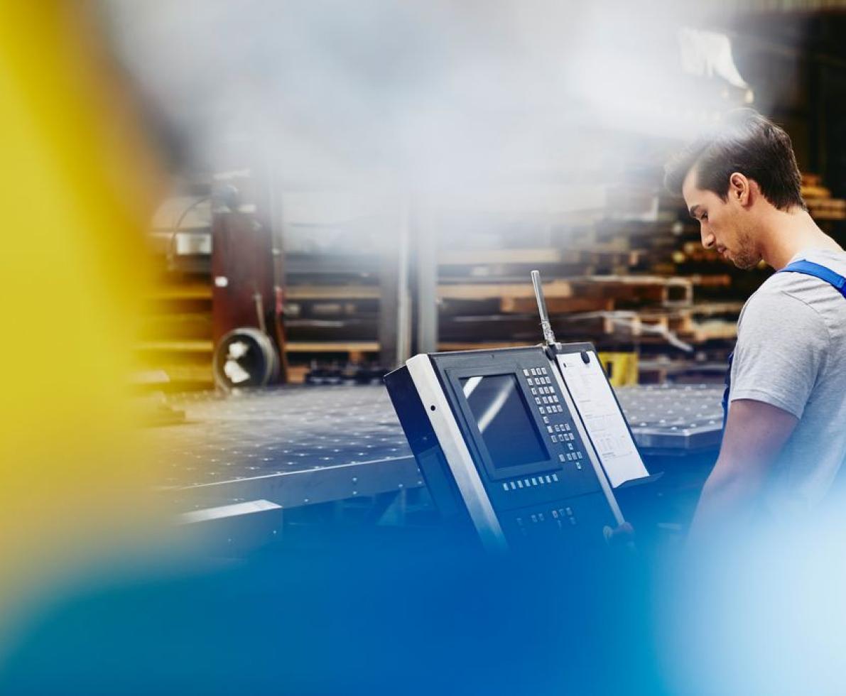 Male blue-collar worker operating a device. Caucasian man. Looking at a display with buttons and switches.