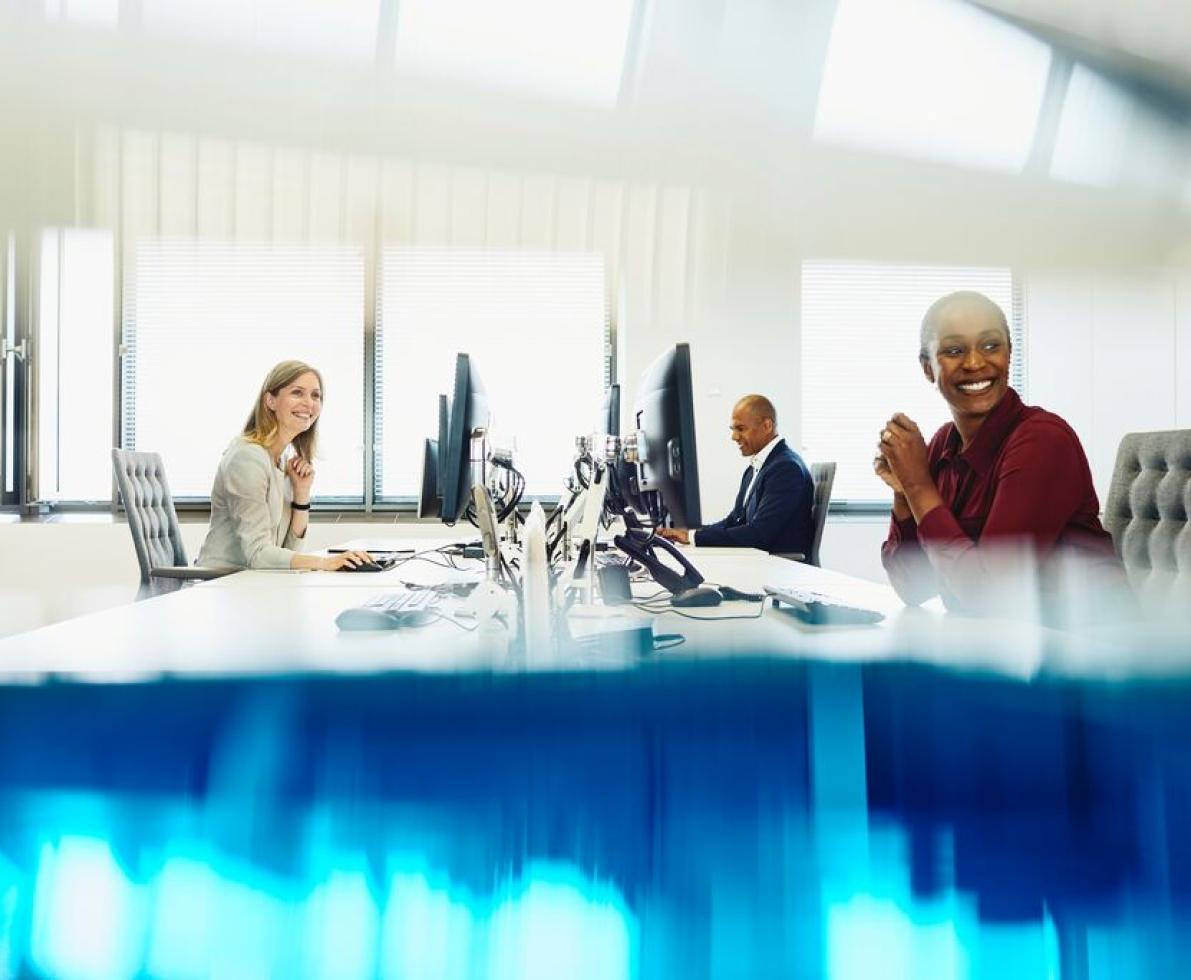 A photo of a group of two women and a man in an office working as HR advisors
