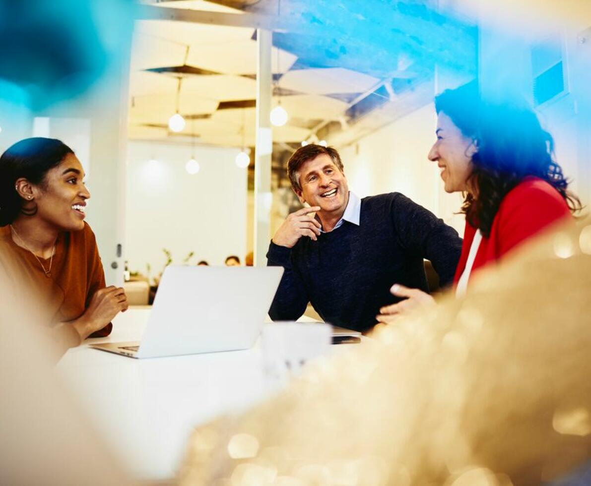 A photo of two women and a man conversing about careers in finance and accounting