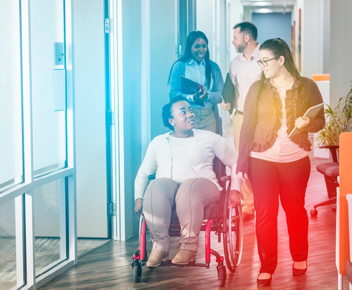 A woman in a wheelchair with another woman talking to her