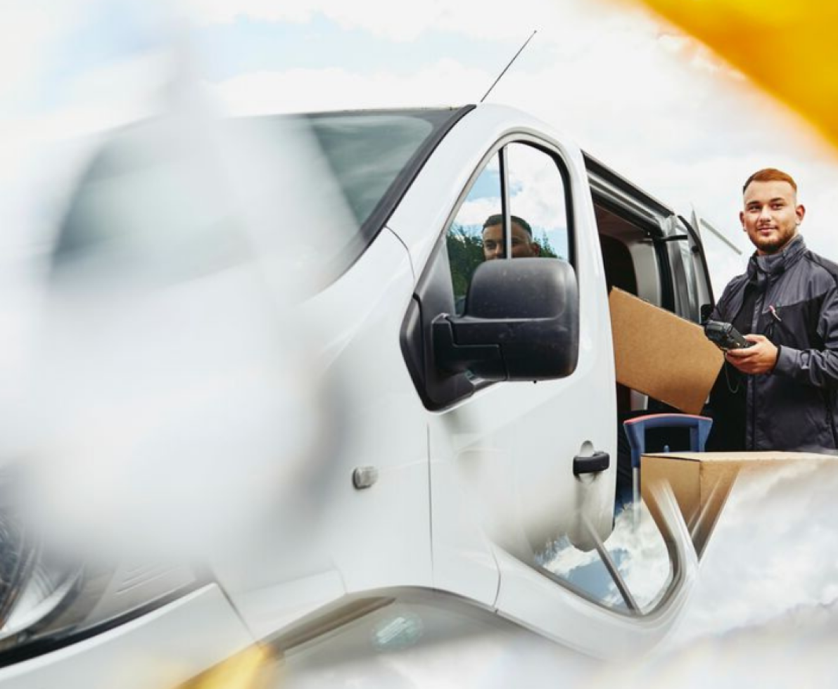 A photo of a man driving a van off to deliver packages A photo of a man driving a van off to deliver packages
