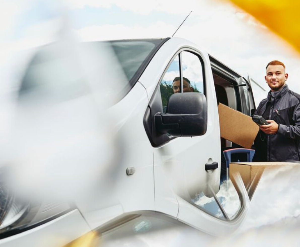 A photo of a man driving a van off to deliver packages