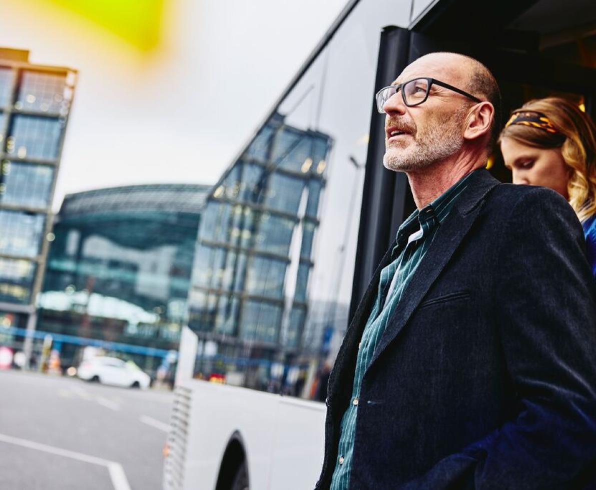 Old man with a woman going getting off a bus