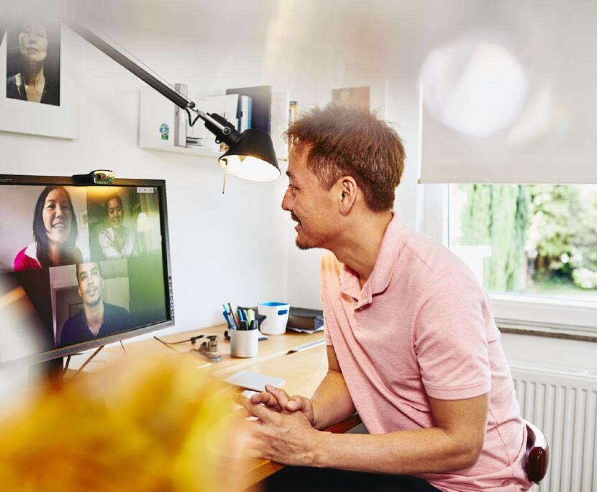 Man sitting at desk in his home office, meeting colleagues in a online meeting. Man sitting at desk in his home office, meeting colleagues in a online meeting.