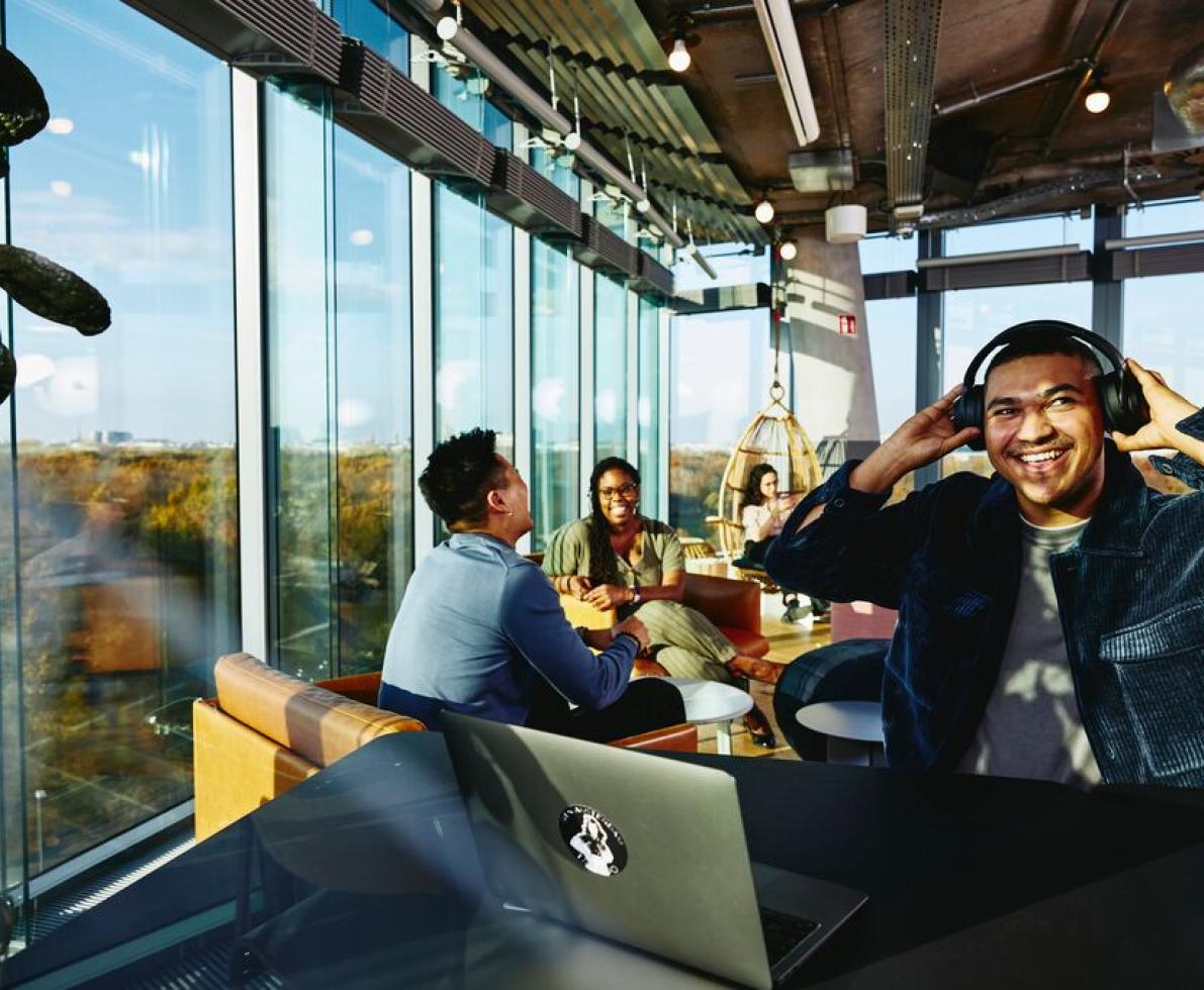 Man listening to music in a cafe with people talking in the back