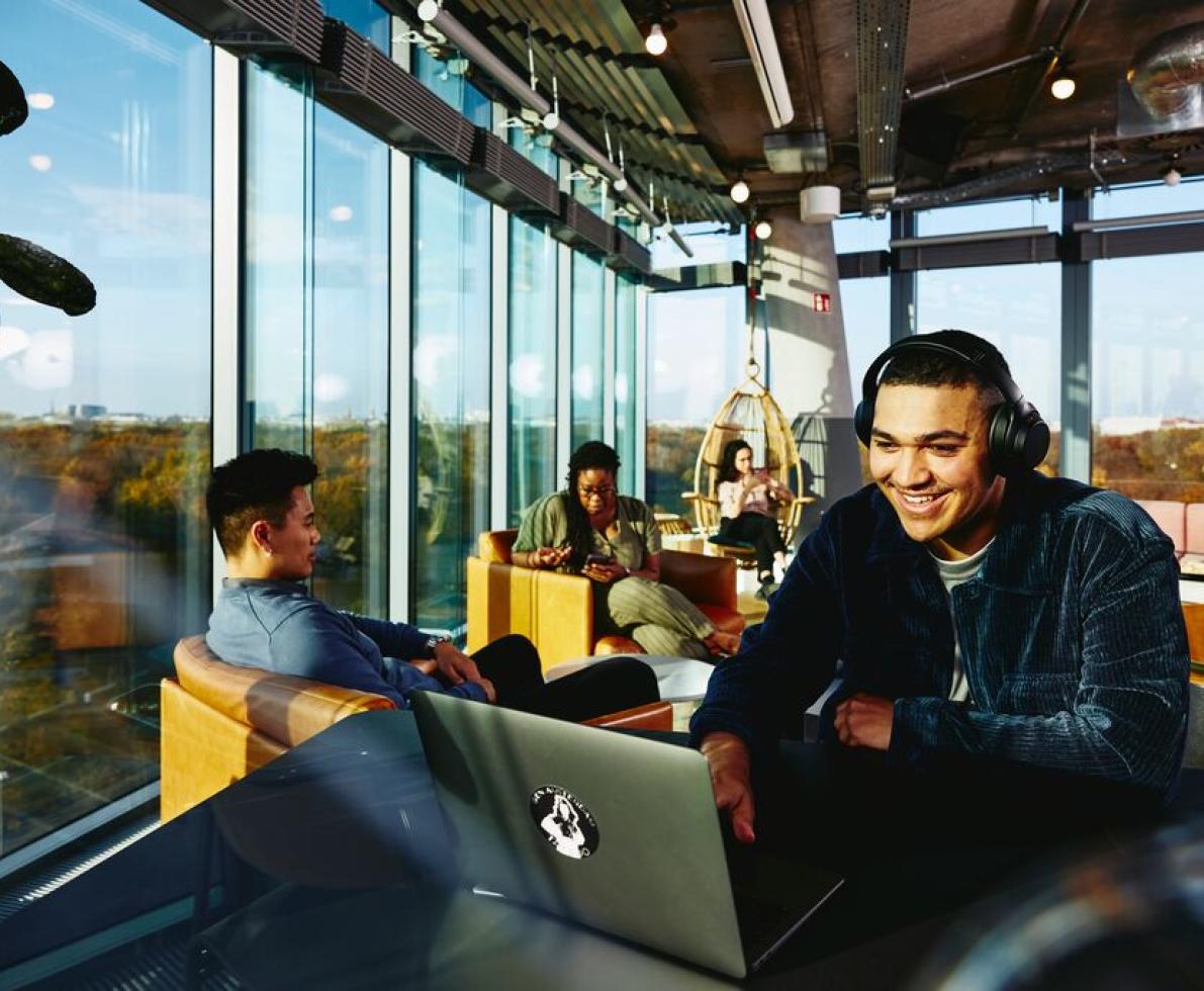 man smiling with headphones and computer